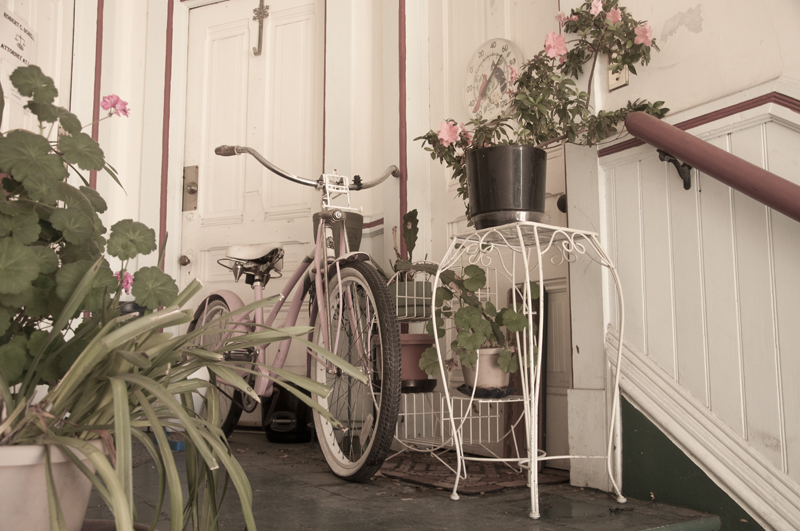 Bicycle decorated with flowers parked on a sunlit street