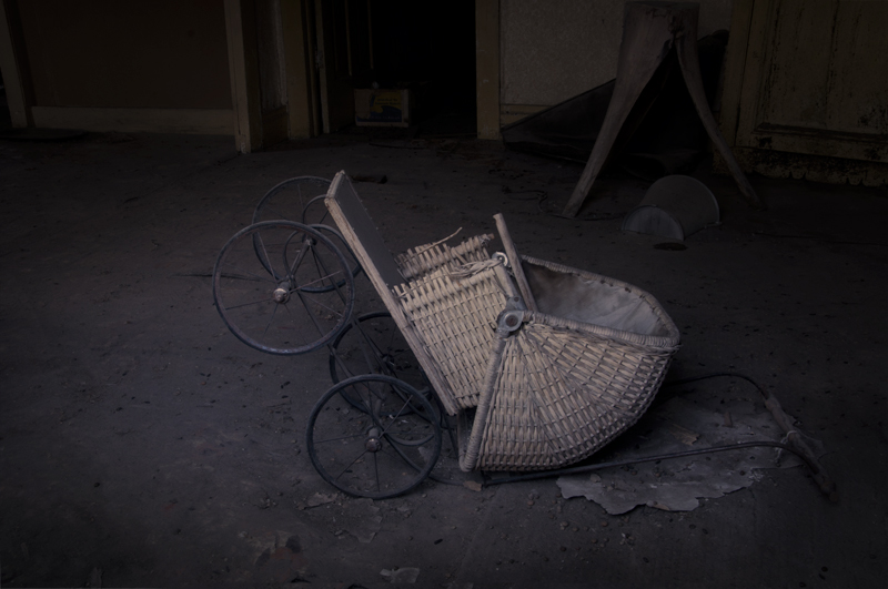 Old baby buggy abandoned on wooden floorboards