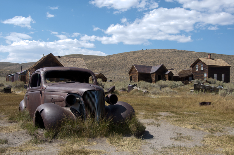 Ghost town street with an abandoned vintage car