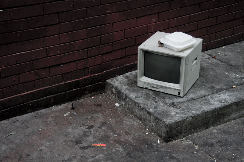 Broken computer discarded on a sidewalk
