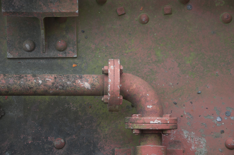 Old metal pipe protruding from desert ground